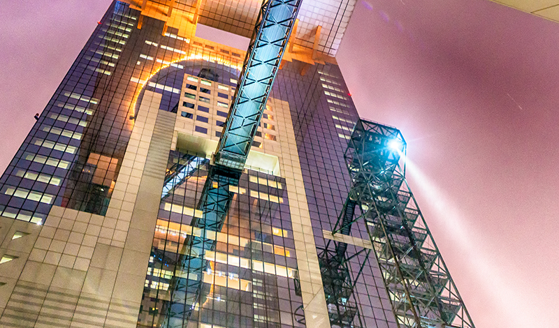 Umeda Sky Building from street level at night in Osaka, Japan.